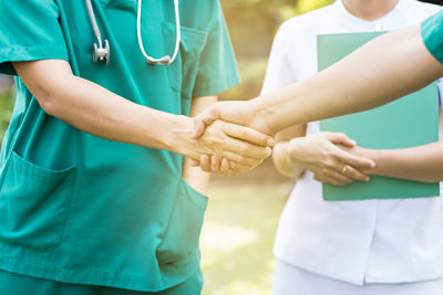 two people in scrubs shaking hands